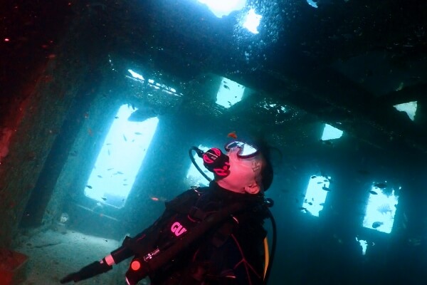 ダイビングをして水中の沈船の中に入っている写真
