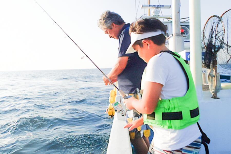 船上から釣りをする男の子の写真